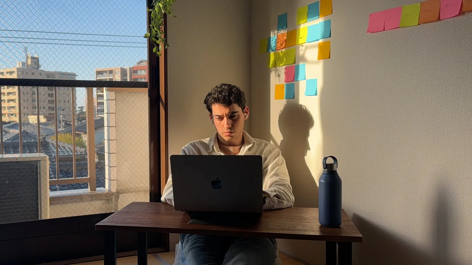 Kian Noren writing in front of a wall covered in notes